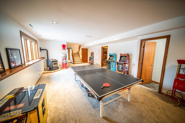 recreation room featuring carpet flooring and a wood stove