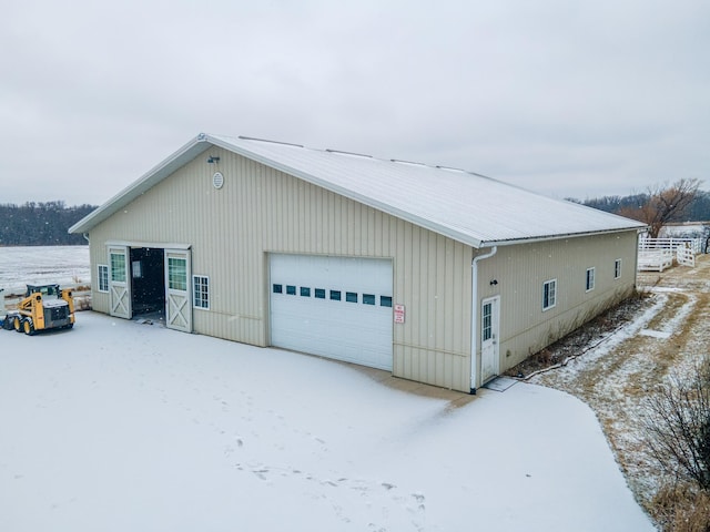 view of snow covered exterior with a garage