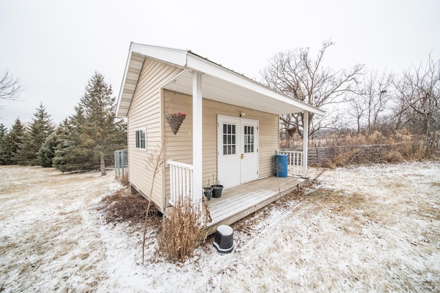 view of snow covered exterior featuring an outbuilding