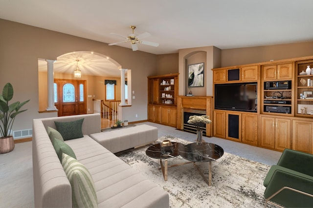 carpeted living room featuring ceiling fan and ornate columns