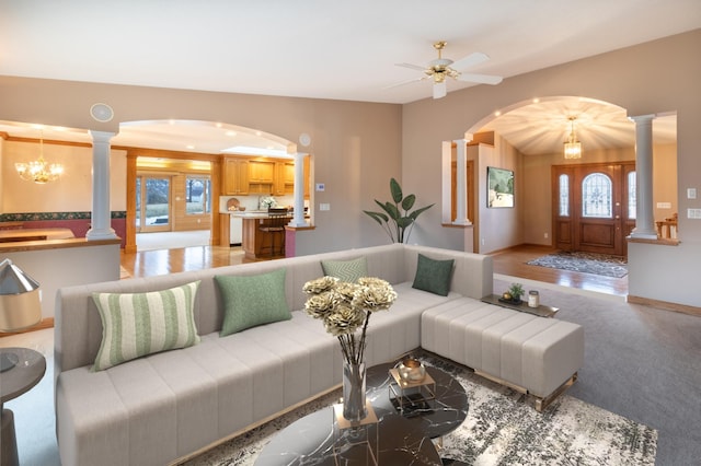 carpeted living room with plenty of natural light and ceiling fan with notable chandelier