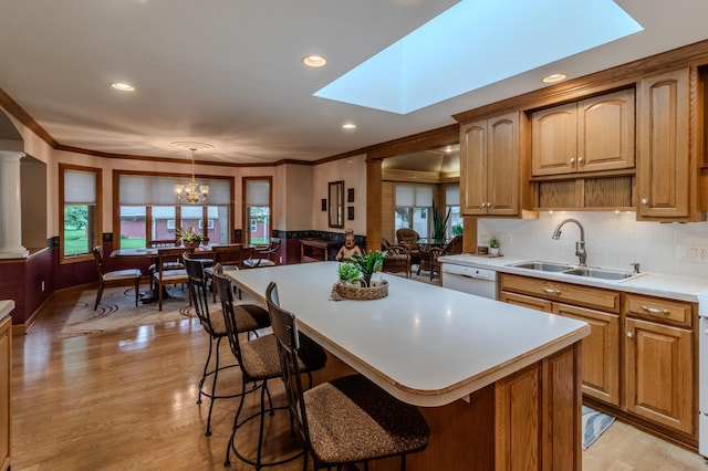 kitchen with pendant lighting, white dishwasher, sink, a wealth of natural light, and a kitchen island