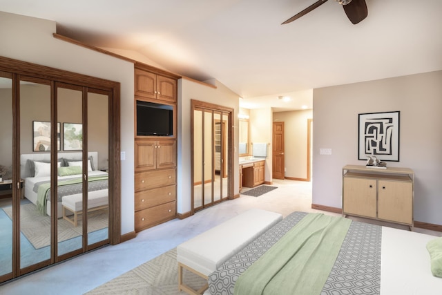 carpeted bedroom featuring ensuite bathroom, ceiling fan, and lofted ceiling