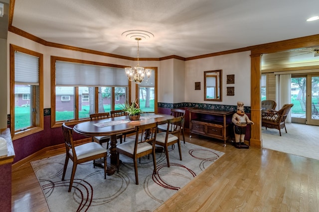 dining space featuring wood-type flooring, crown molding, and an inviting chandelier