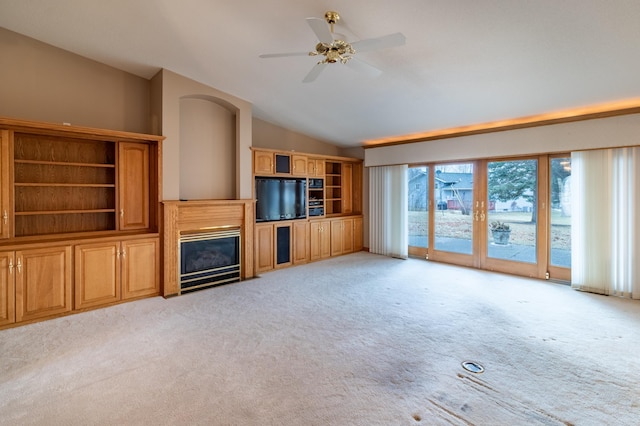 unfurnished living room featuring ceiling fan, light colored carpet, and vaulted ceiling