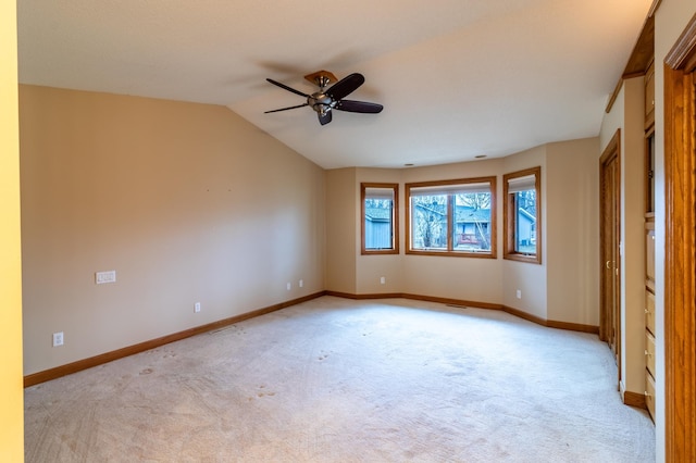 carpeted spare room with ceiling fan and lofted ceiling