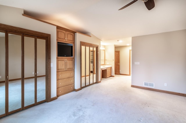 unfurnished living room featuring ceiling fan, light carpet, and vaulted ceiling