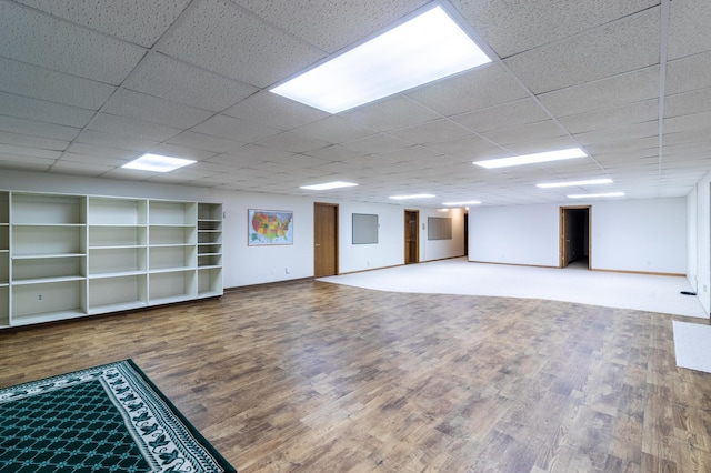 basement featuring wood-type flooring and a paneled ceiling