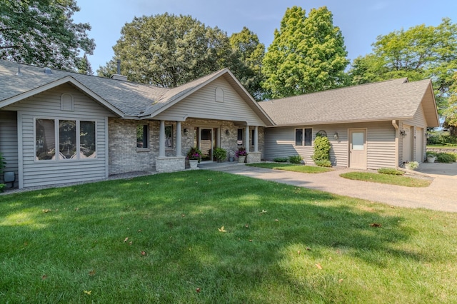 ranch-style home with covered porch, a garage, and a front yard