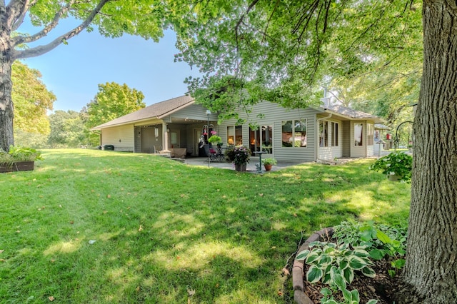 rear view of house featuring a yard and a patio