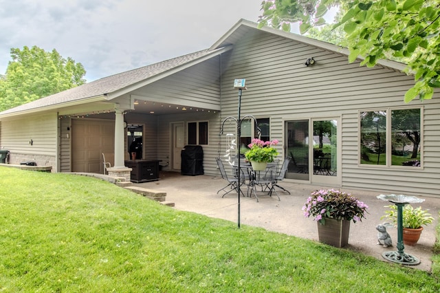 back of property with a yard and a patio