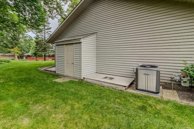 view of outdoor structure with central air condition unit and a lawn