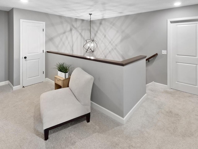 living area with an inviting chandelier and carpet