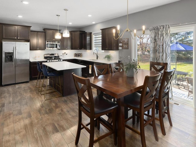 dining room featuring sink, a notable chandelier, and hardwood / wood-style floors