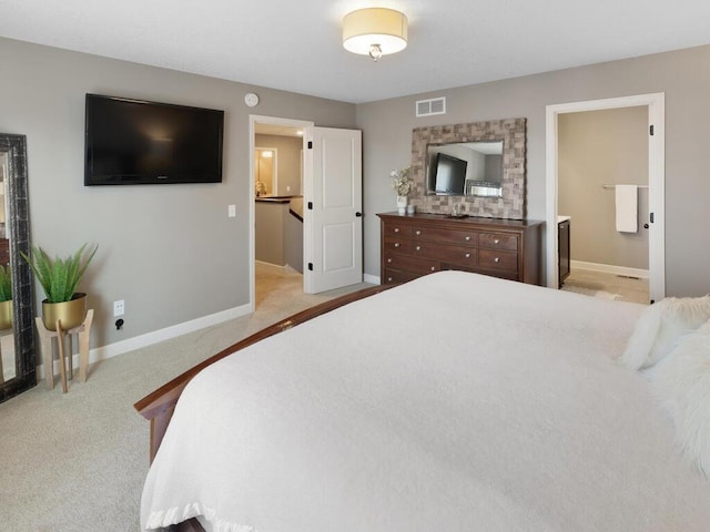 bedroom featuring light carpet and connected bathroom