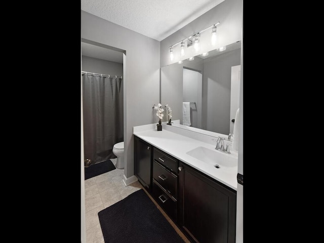 bathroom with vanity, a textured ceiling, curtained shower, tile patterned floors, and toilet