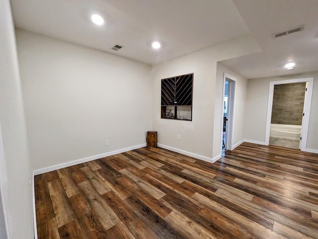 unfurnished room with dark wood-type flooring