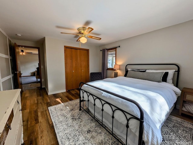 bedroom featuring dark hardwood / wood-style flooring, ceiling fan, and a closet