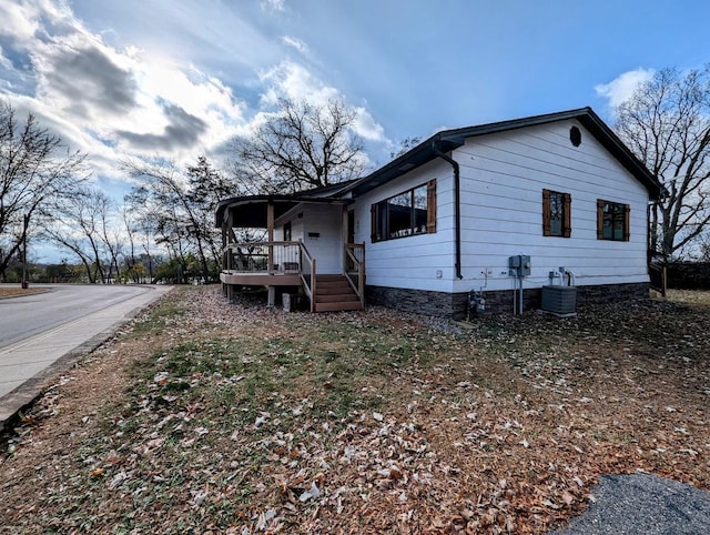 view of side of home featuring a porch and central AC unit