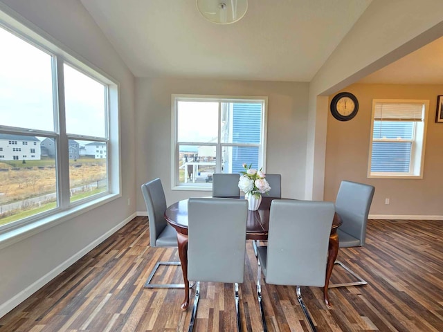 dining space featuring dark hardwood / wood-style flooring and vaulted ceiling