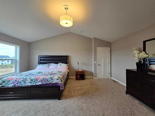 carpeted bedroom with a textured ceiling and lofted ceiling