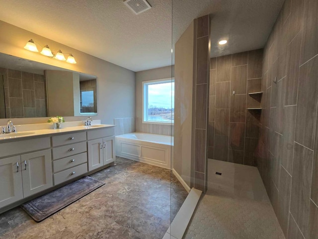 bathroom featuring vanity, separate shower and tub, and a textured ceiling