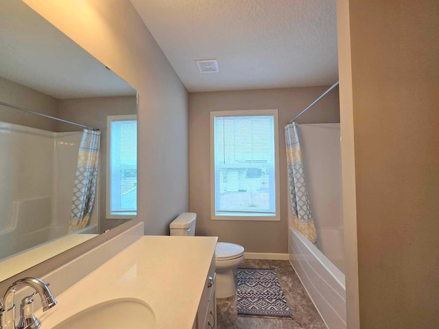 full bathroom with a textured ceiling, vanity, toilet, and plenty of natural light