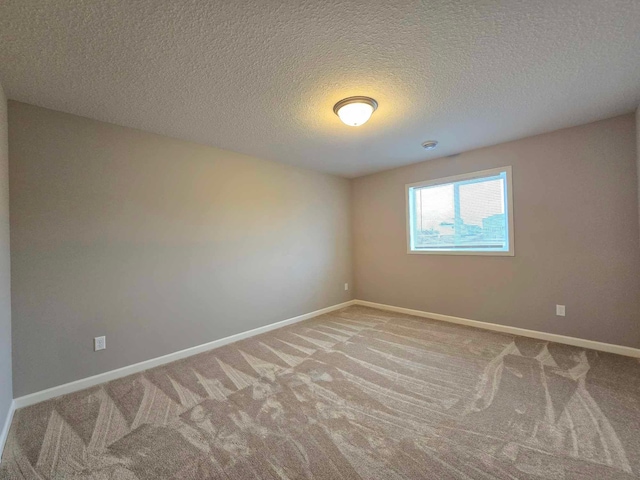 carpeted spare room with a textured ceiling