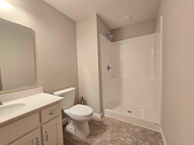 bathroom with a shower, vanity, a textured ceiling, and toilet