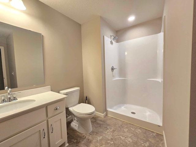 bathroom featuring walk in shower, vanity, and toilet