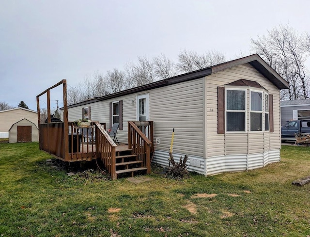 rear view of house featuring a lawn and a deck