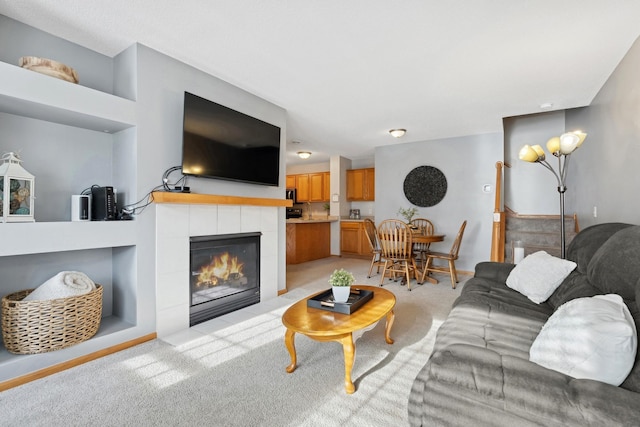 carpeted living room with built in shelves and a tiled fireplace