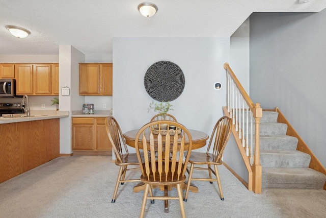 dining space with light colored carpet and sink