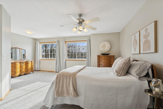 carpeted bedroom with ceiling fan and a textured ceiling