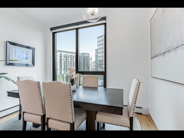 dining room featuring floor to ceiling windows, a healthy amount of sunlight, baseboard heating, and light hardwood / wood-style flooring