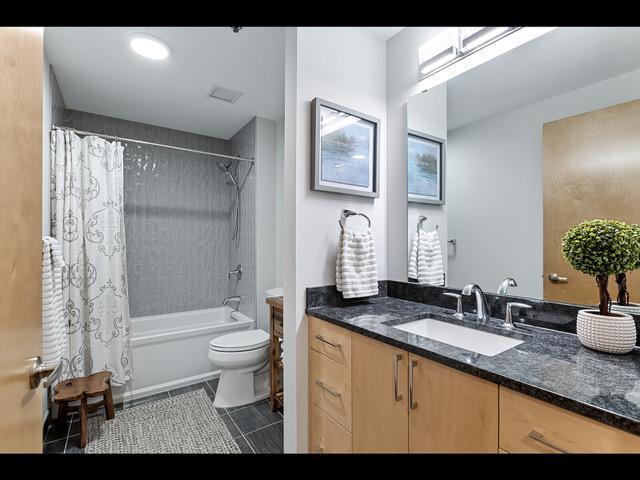 full bathroom with tile patterned flooring, shower / bath combination with curtain, vanity, and toilet