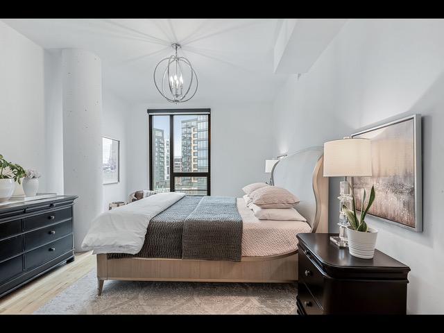 bedroom with light wood-type flooring and a chandelier