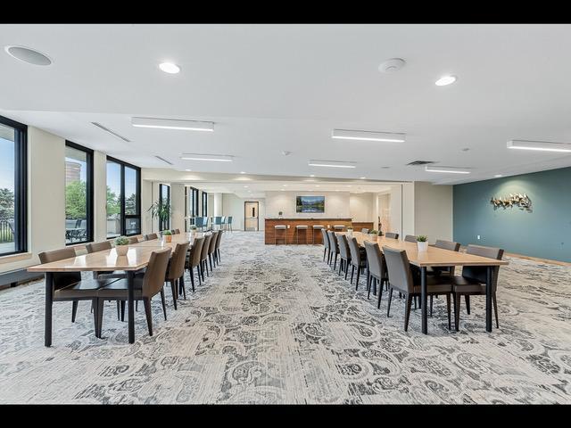 carpeted dining area featuring a wall of windows