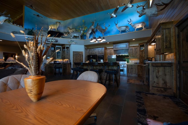 dining space with tile patterned floors, wooden ceiling, and a high ceiling