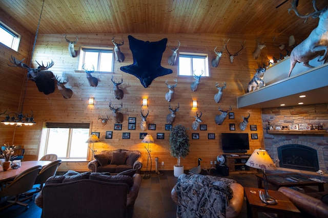 living room with hardwood / wood-style flooring, a stone fireplace, plenty of natural light, and wooden ceiling