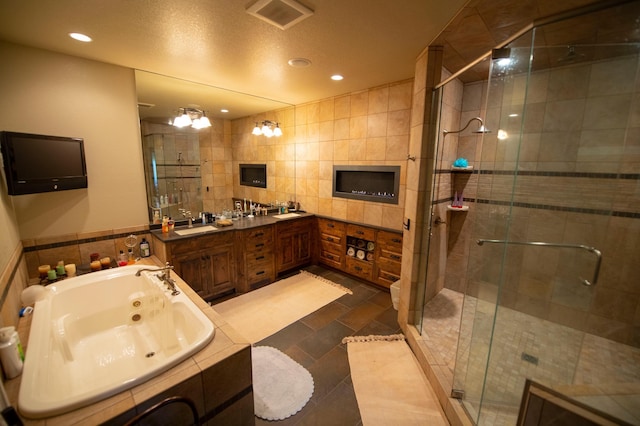 bathroom featuring shower with separate bathtub, vanity, tile patterned floors, and tile walls