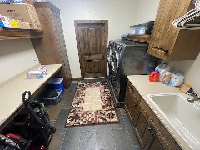 clothes washing area with sink, cabinets, and independent washer and dryer