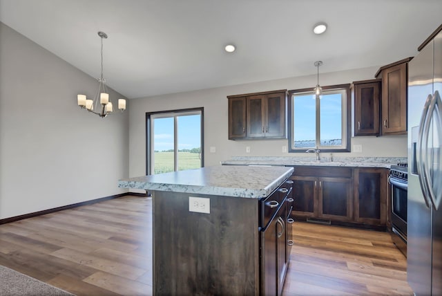 kitchen featuring dark brown cabinets, a center island, decorative light fixtures, and appliances with stainless steel finishes