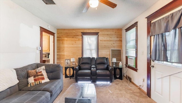 205 Broadway St SE, Isanti, MN 55040 - living area featuring light colored carpet, ceiling fan, wooden walls, and a textured ceiling