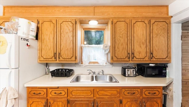 205 Broadway St SE, Isanti, MN 55040 - kitchen featuring black microwave, freestanding refrigerator, light countertops, and brown cabinetry