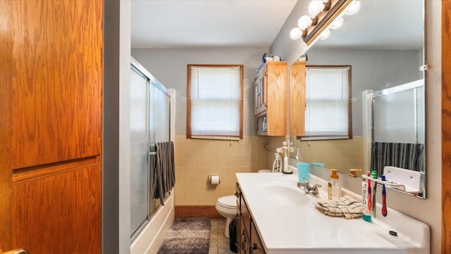 205 Broadway St SE, Isanti, MN 55040 - bathroom featuring vanity, tile walls, a wainscoted wall, and tile patterned flooring