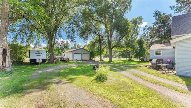 205 Broadway St SE, Isanti, MN 55040 - view of green lawn featuring a garage, dirt driveway, and an outdoor structure