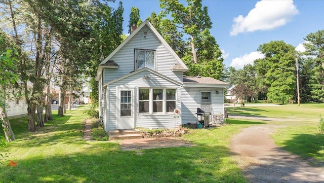 205 Broadway St SE, Isanti, MN 55040 - rear view of property with a lawn and a chimney