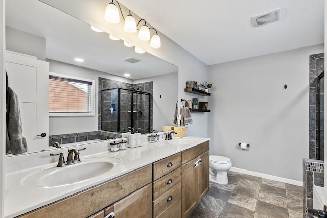 bathroom with vanity, toilet, and a shower with door