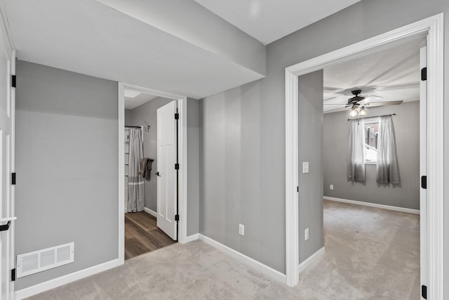 interior space featuring ceiling fan and light colored carpet